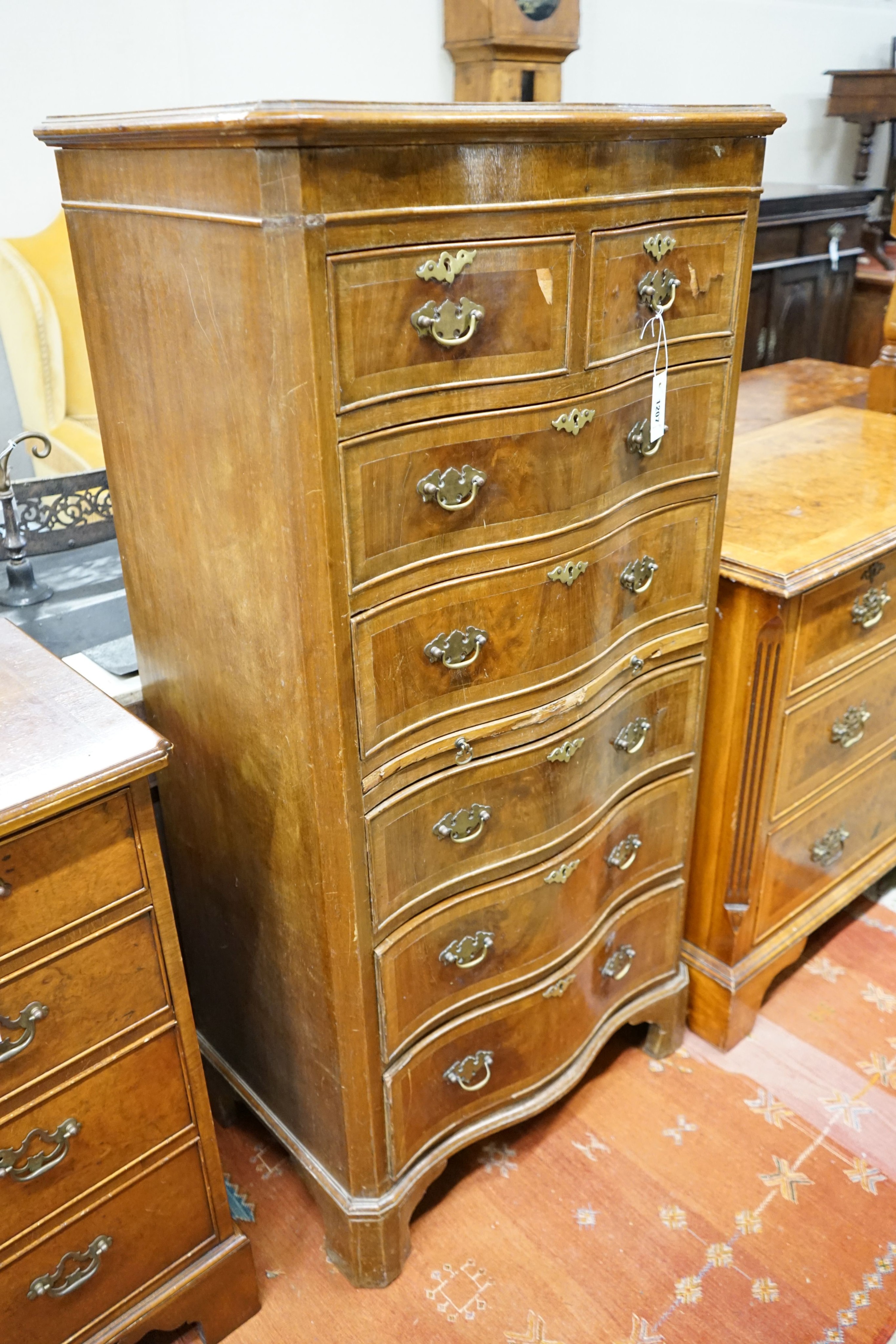 A reproduction 18th century style serpentine walnut tall chest fitted slide, width 66cm, depth 43cm, height 134cm